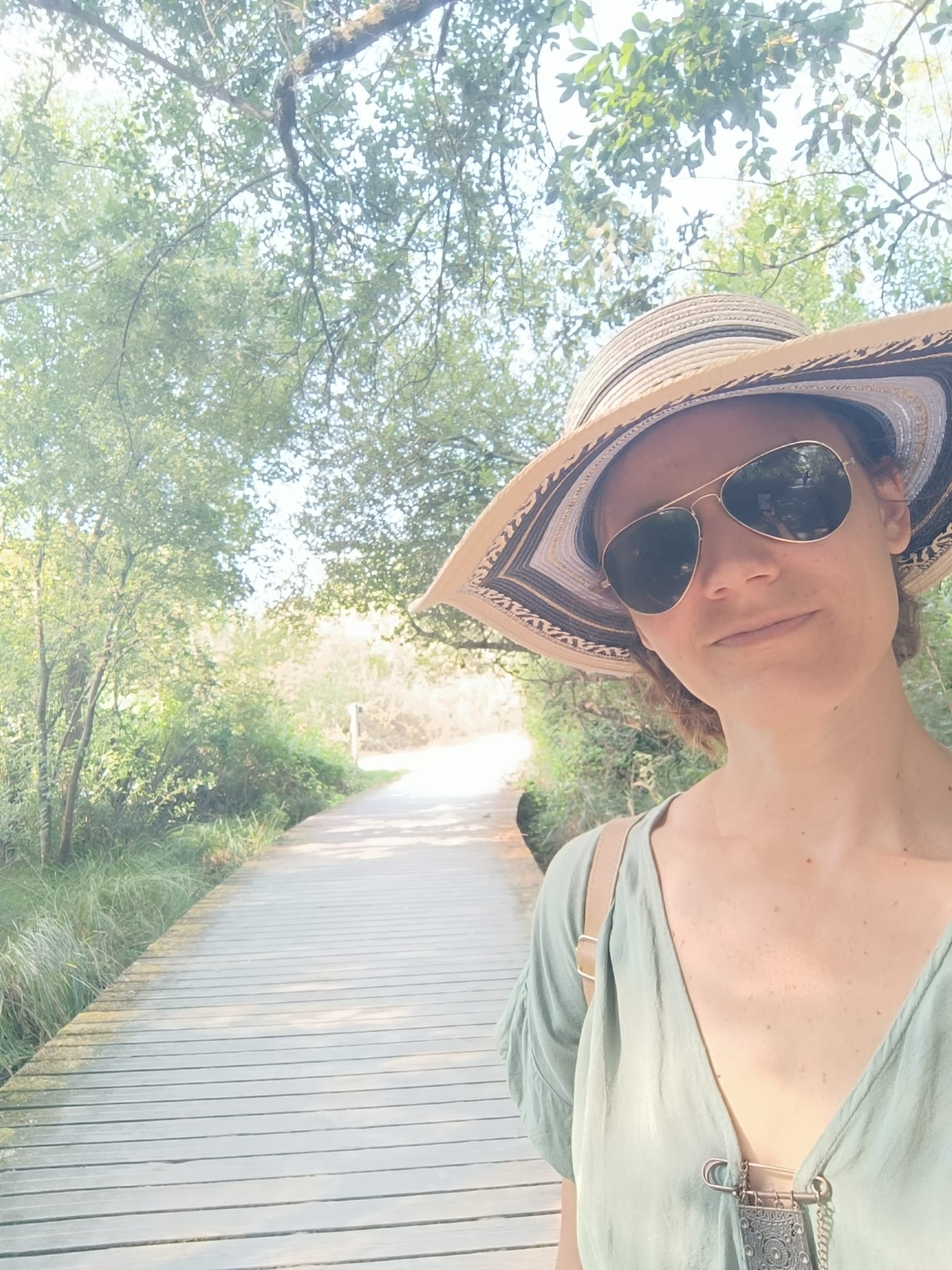 Femme en chemin avec son chapeau et ses lunettes