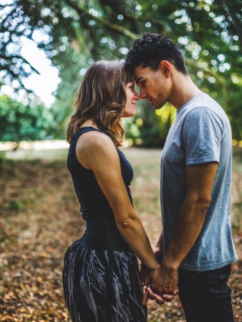 Couple se regarde, front contre front, mains dans les mains