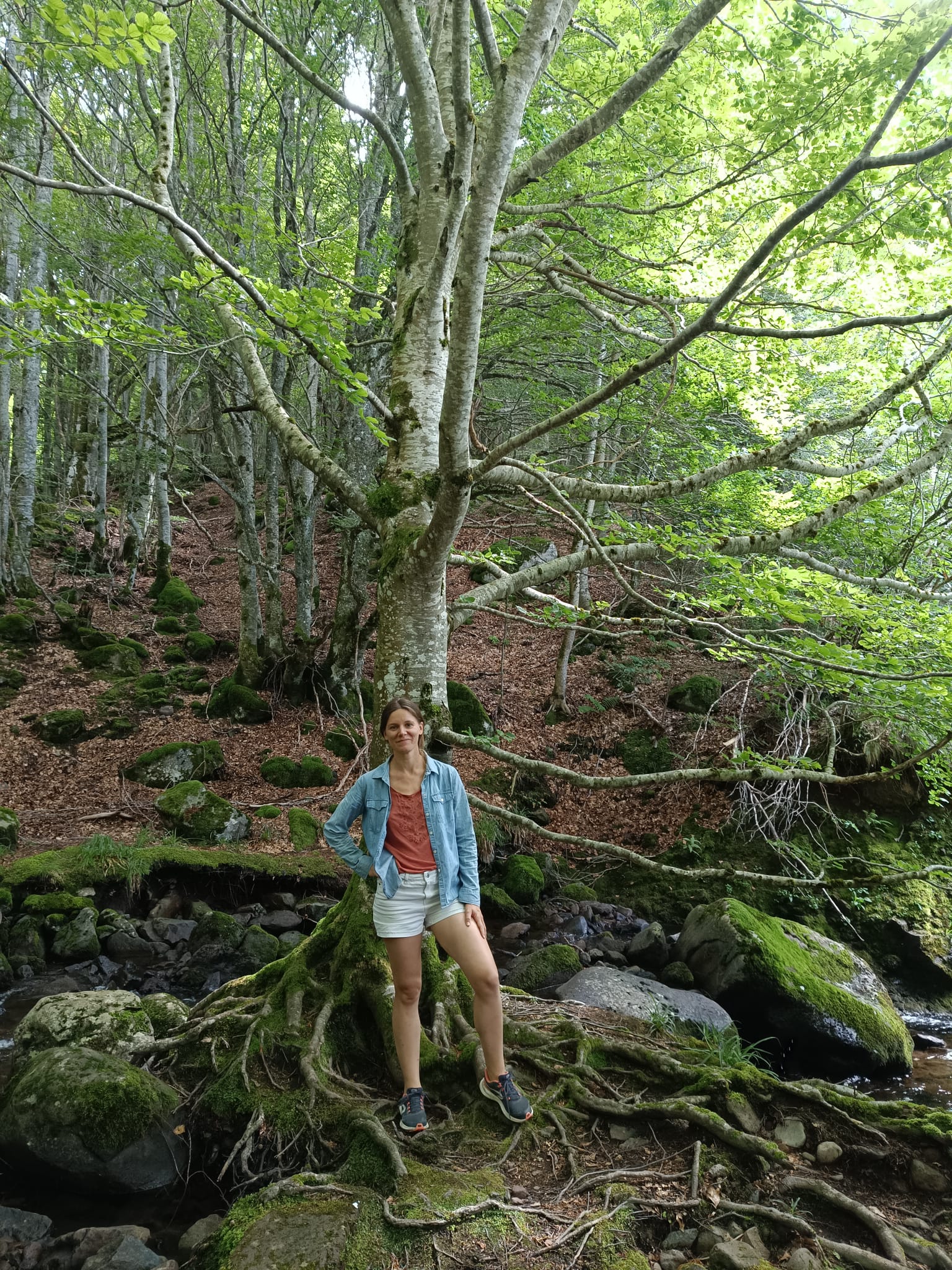 Une femme debout devant un arbre