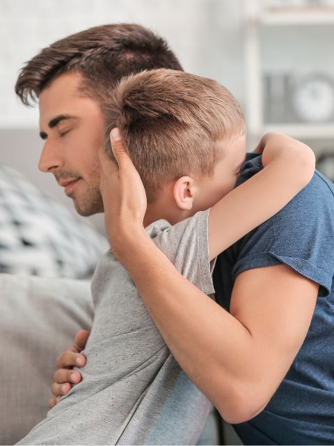 Un père et son fils se serrent dans les bras