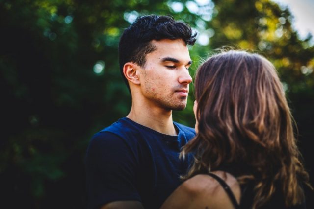 Couple dans les bras, l'homme regarde la femme